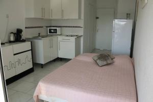 een kleine keuken met een bed in een kamer bij Studio 82, Héliopolis FGH au Village naturiste in Cap d'Agde