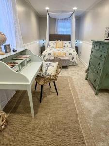 刘易斯Crow's Nest - Private Guest Apt Near Bike Trail/3.7 mi to Beach的一间卧室，配有一张床、一张桌子和一把椅子