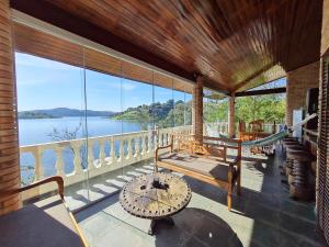 eine Veranda mit Hängematte und Blick auf das Wasser in der Unterkunft Chalé Karin Sampaio in Jacareí