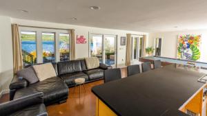 a living room with a couch and a ping pong table at Lakefront, Dock, Hottub, Pooltable, Kayaks, 75"tv in Lake Ariel