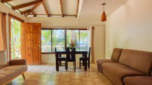 uma sala de estar com uma mesa e cadeiras e um sofá em Arrecife Punta Uva - Hospedaje, bar y restaurante - Frente al mar em Punta Uva