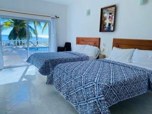 a bedroom with two beds and a view of the ocean at Hotel Costa Linda in Tolú