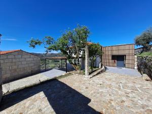 un gran patio con un edificio y un árbol en Vila Campo, en Alcofra