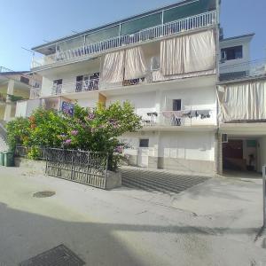 an apartment building with balconies and flowers in front of it at Guest house Milic in Makarska