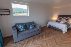 a living room with a couch and a bed at OAKWOOD GLAMPING Mourne Mountains in Moyad