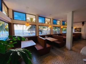 Hotel Costa Linda في تولو: مطعم بطاولات وإطلالة على الشاطئ
