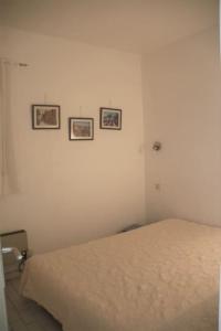 een slaapkamer met een bed en drie foto's aan de muur bij Appart 801, Tennis village in Cap d'Agde