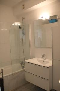een badkamer met een wastafel, een douche en een spiegel bij Appart 801, Tennis village in Cap d'Agde