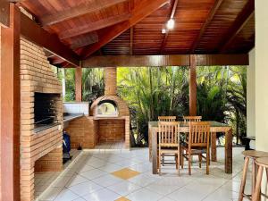 a patio with a table and chairs and a brick oven at Casa com piscina privativa no Paúba um Vilarejo in São Sebastião