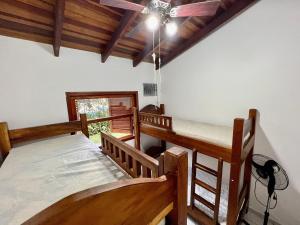um quarto com 2 beliches e uma ventoinha de tecto em Casa com piscina privativa no Paúba um Vilarejo em São Sebastião