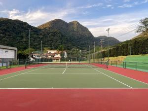 a tennis court with mountains in the background at Casa com piscina privativa no Paúba um Vilarejo in São Sebastião