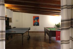 una habitación con una mesa de ping pong y una pintura en The Wild Olive Andalucía Palma Guestroom en Casares