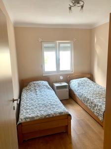 sypialnia z 2 łóżkami i oknem w obiekcie Apartments Neira near Dubrovnik w mieście Ivanica