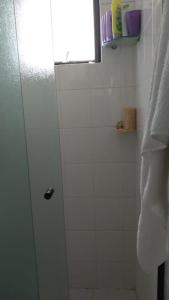 ein Bad mit einer Dusche und einer Glastür in der Unterkunft Apto confortável in Solemar