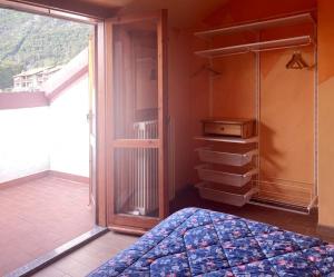 um quarto com uma cama e uma porta de vidro deslizante em Spacious mountain view attic apartment em Barzio
