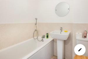 a bathroom with a tub and a sink and a mirror at Affordable single room 