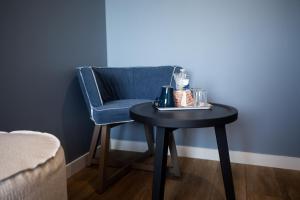 a blue chair with a black table and a blue stool at Hôtel de la Baie in Crozon