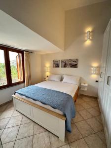 um quarto com uma cama com um cobertor azul em Sardegna Costa Corallina Appartamento Luxury Vista Mare in splendido villaggio - IUN R6511 em Costa Corallina