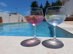 two wine glasses sitting on a table near a swimming pool at Casa A.Mar in Las Negras