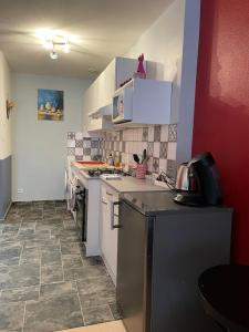 a kitchen with white cabinets and a tile floor at Appartement COSY rue Chaussée in Verdun