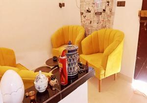 薩菲的住宿－Welcome to a small apartment near Ras El Lefa Beach，两个黄色的椅子和一张桌子
