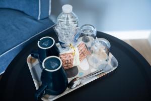 a tray with a bottle of water and other items on a table at Hôtel de la Baie in Crozon