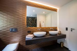 two sinks in a bathroom with a mirror at PRIMERA am See in Gaienhofen