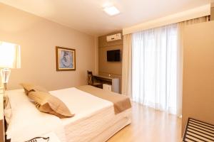 Postel nebo postele na pokoji v ubytování Curitiba Palace Hotel