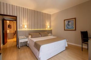 Postel nebo postele na pokoji v ubytování Curitiba Palace Hotel