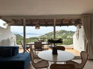 uma sala de estar com um sofá azul e uma mesa em Sardegna Costa Corallina Appartamento Luxury Vista Mare in splendido villaggio - IUN R6511 em Costa Corallina