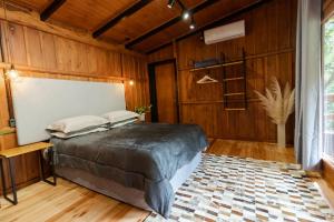 a bedroom with a bed in a room with wooden walls at Cabana Grafe in Bento Gonçalves