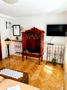 a living room with a tv and a wooden floor at Villa Urbana, Old Town Budva in Budva