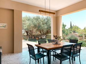 a dining room with a table and chairs at Olivar Holiday House in Alykes