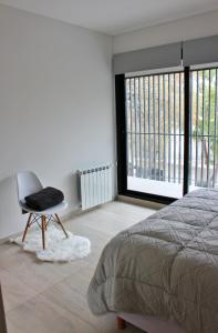 ein Schlafzimmer mit einem Bett, einem Stuhl und einem Fenster in der Unterkunft Mendoza Relax and Comfort II in Mendoza
