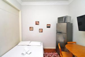 Habitación pequeña con 2 camas y nevera. en Rio Spot Homes Copacabana U041, en Río de Janeiro