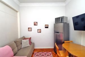 uma sala de estar com um sofá, uma mesa e um frigorífico em Rio Spot Homes Copacabana U041 no Rio de Janeiro