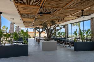 a restaurant with tables and chairs and potted plants at Ayvalık Sea Long in Ayvalık