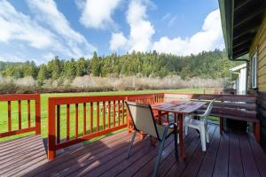 a wooden deck with a table and chairs on it at Elk Meadow Cabins 9A Prairie Creek Suite in Orick