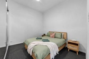 a bedroom with a bed with a blanket on it at Bay Vista Two Bedroom Waterfront Apartment in Redcliffe