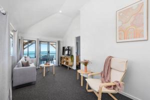a living room with a couch and a chair at Bay Vista Two Bedroom Waterfront Apartment in Redcliffe