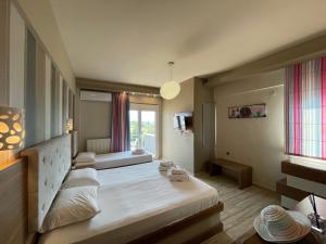 a large bedroom with two beds and a window at Porto Del Sol Hotel in Paralia Katerinis