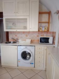 a kitchen with a washing machine and a microwave at Casa girasole in Isola del Giglio
