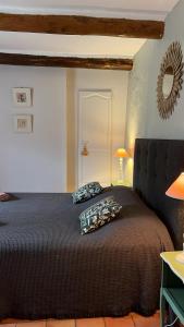 um quarto com uma grande cama preta num quarto em Domaine La Condamine CRILLON LE BRAVE em Crillon-le-Brave