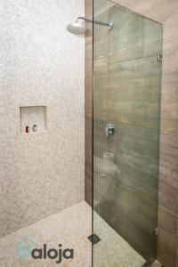 a shower with a glass door in a bathroom at Hotel Zendero Tulum in Tulum