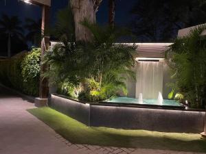 a fountain in the middle of a garden at night at Kingston Resort in Kānpur