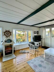 a living room with a fireplace and a table at Southern cottage with terrace and magnificent view in Lillesand