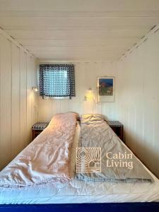 a bedroom with a bed in a small room at Southern cottage with terrace and magnificent view in Lillesand