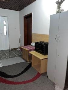 a room with a microwave on a table and a refrigerator at Villa Natalija in Podgorica
