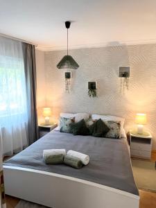 a bedroom with a large bed with two pillows on it at Selyemakácapartman in Balatonlelle