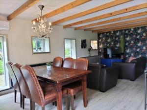 een eetkamer met een houten tafel en lederen stoelen bij Leuk boerderijtje op prachtige plek, nabij natuurgebied in Ruurlo